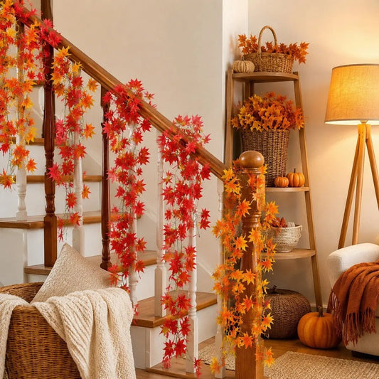 Faux red and orange maple leaf garlands wrapped around staircase railing with pumpkins and wicker baskets, autumn indoor decor