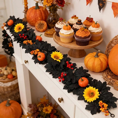 Black autumn garland with yellow sunflowers, orange pumpkins, and red berry clusters draped along a white console table with Halloween cupcakes, orange pumpkins, and wicker baskets for fall harvest party display