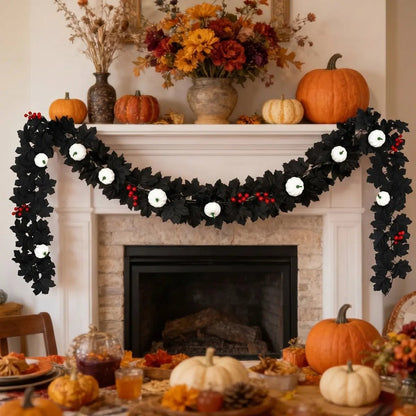 Black maple leaf garland with white pumpkins and red berry clusters draped across a white stone fireplace mantel surrounded by orange and white pumpkins, fall flowers, and a Thanksgiving harvest table setting