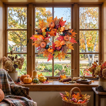 Fall harvest wreath with pumpkins and autumn leaves displayed on a window with warm interior lighting and fireplace