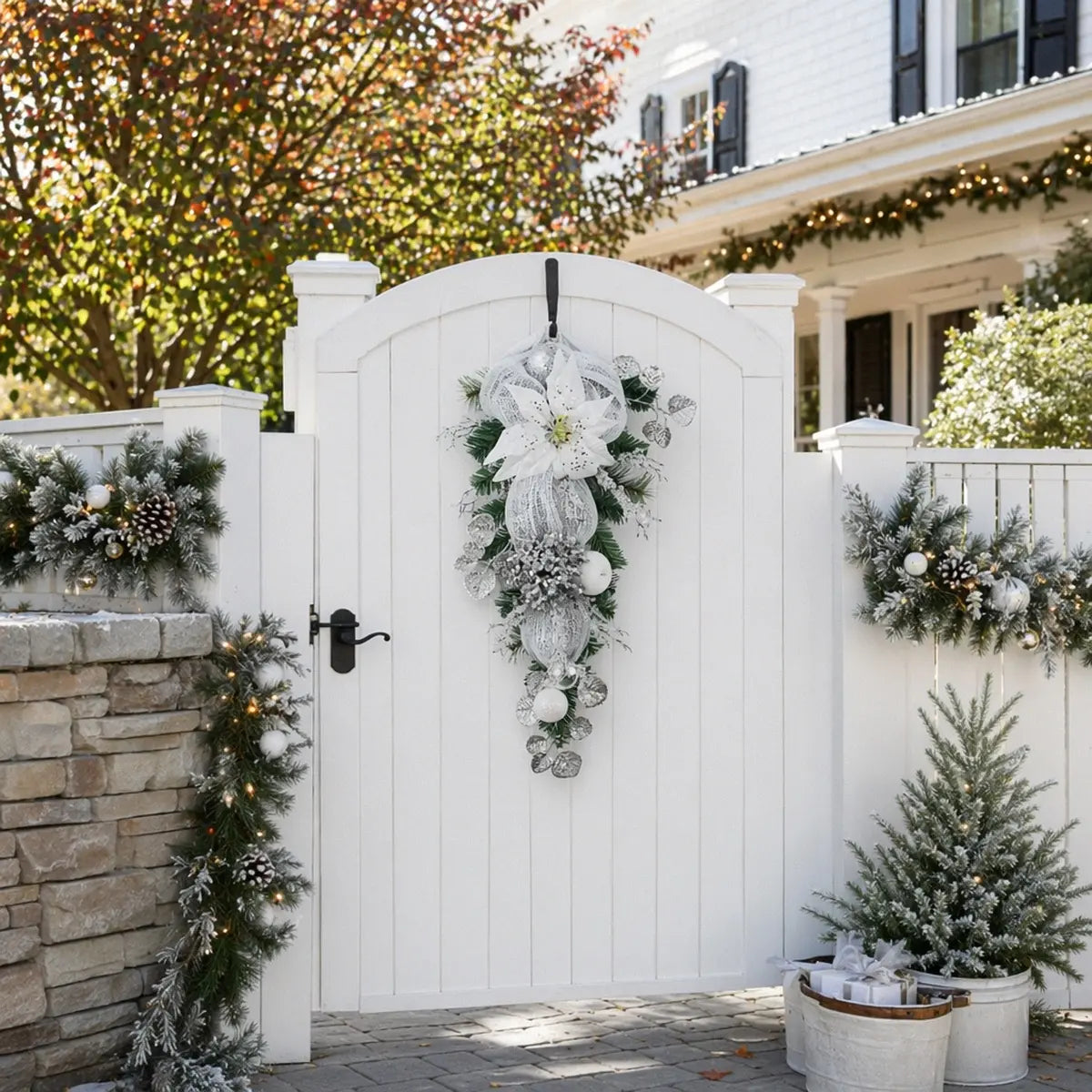 27.6 inch silver white Christmas teardrop swag with white poinsettia and shatterproof ball ornaments, hung on white outdoor gate for front door holiday decor
