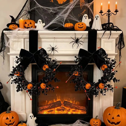 Gothic Halloween mini wreath with black boxwood, orange pumpkins and black velvet bow displayed on a fireplace mantel with Halloween decorations