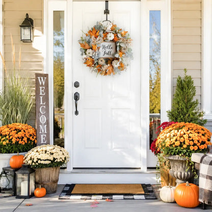 Thanksgiving fall wreath with eucalyptus, berries and pumpkins hanging on a white front door with lanterns and fall porch decor