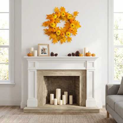 Fall wreath with pumpkins and autumn maple leaves displayed above a fireplace mantel for Thanksgiving harvest decor
