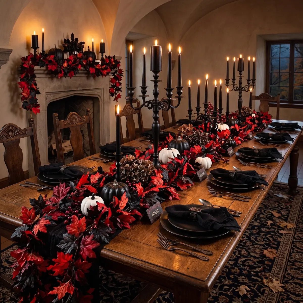 Red and black maple leaf fall garlands used as table runner and fireplace mantel garland in a gothic Halloween dining room with black candelabras, black plates, black and white pumpkins, pine cones, and dark candlelight ambiance