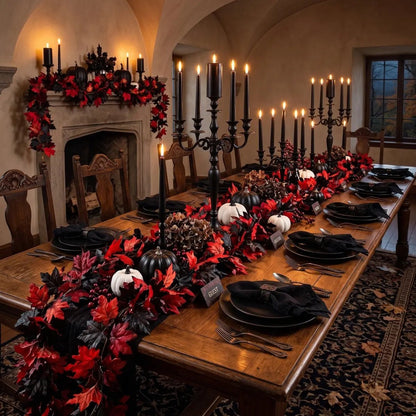 Red and black maple leaf fall garlands used as table runner and fireplace mantel garland in a gothic Halloween dining room with black candelabras, black plates, black and white pumpkins, pine cones, and dark candlelight ambiance