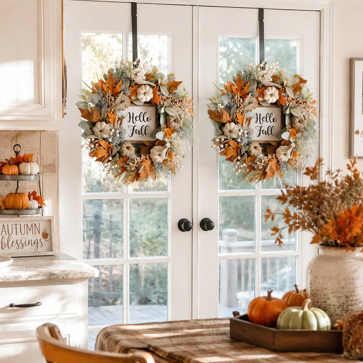 Thanksgiving fall wreaths with eucalyptus and pumpkins displayed on double white French doors with porch pumpkins and autumn foliage
