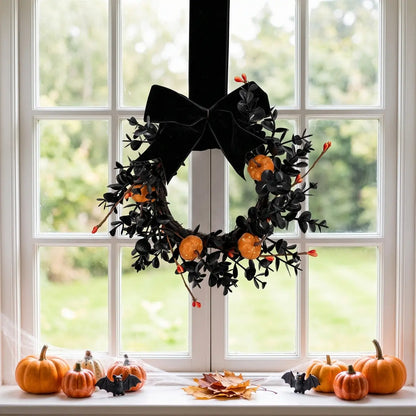 Gothic Halloween mini wreath with black velvet bow and orange pumpkins hanging on a window with fall seasonal decor