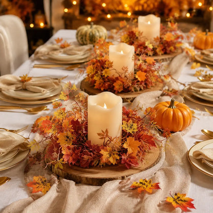 Fall maple leaf candle ring wreaths with red orange and yellow leaves styled around pillar candles on a Thanksgiving harvest table setting