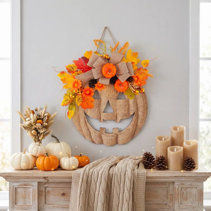 Close-up of burlap pumpkin wreath showing patchwork pumpkin face with orange floral accents and autumn foliage