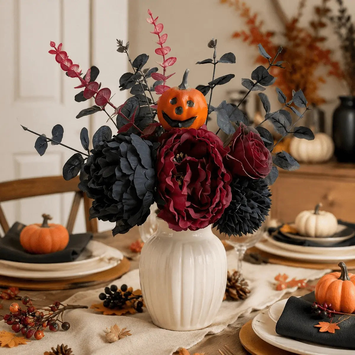 Halloween artificial flower bouquet in white ribbed vase on dining table with pumpkins and fall leaves
