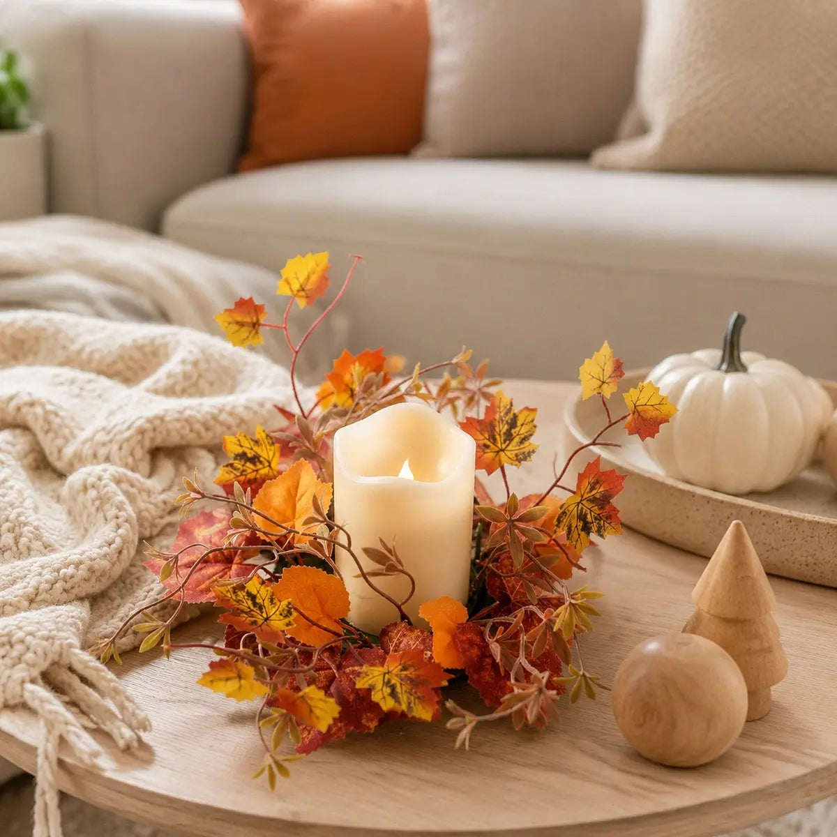 Fall maple leaf candle ring wreaths with autumn foliage displayed around candles on a living room side table with seasonal home decor