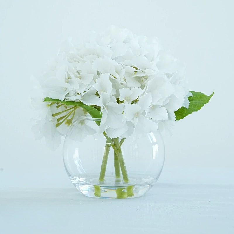 White artificial hydrangea flowers in glass vase for home dining table office decor centerpiece