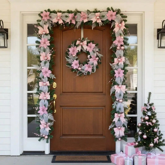 5.9FT pink Christmas cane garland with poinsettia flowers, mesh bows and rose gold ornaments, framing a wooden front door with matching pink wreath, pink gift boxes and small decorated Christmas tree on porch
