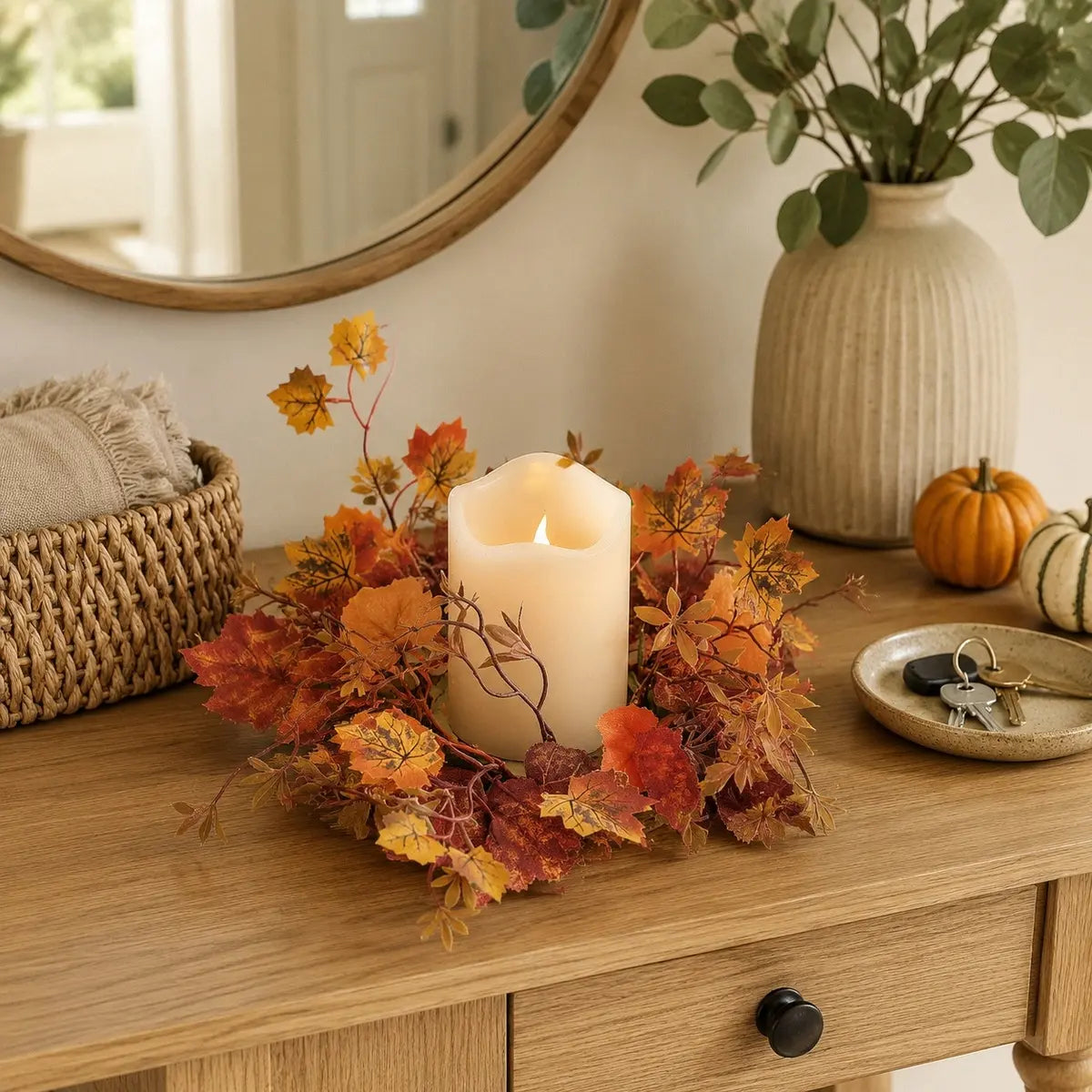 Fall maple leaf candle ring wreaths with mixed autumn leaves arranged around pillar candles on a farmhouse dining table centerpiece