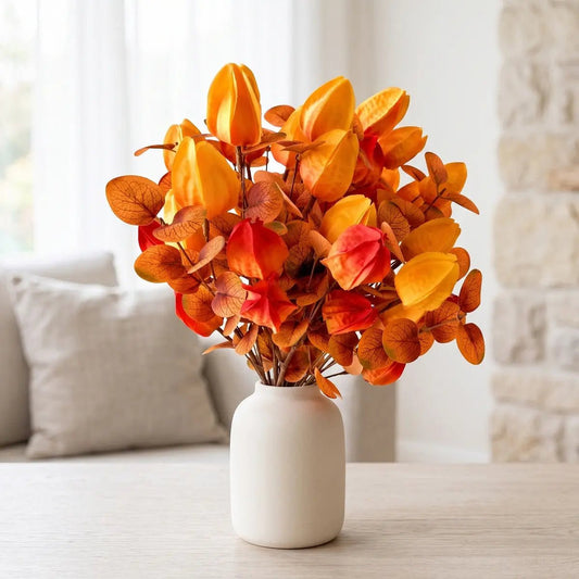 Autumn artificial lantern flower bouquet with orange and red tones in a white vase on a table