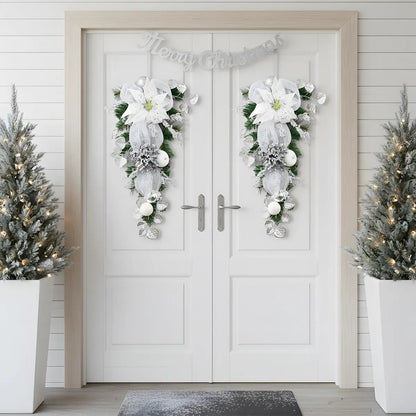 Pair of silver white Christmas teardrop swags with glitter poinsettia and mesh bows, displayed symmetrically on white double front doors with Merry Christmas banner
