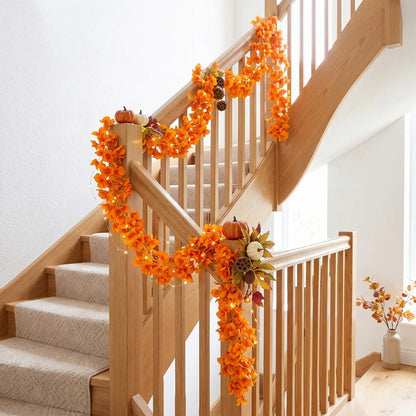 Orange faux bougainvillea flower garland wrapped around wooden staircase railing with mini pumpkins and fairy lights, fall home decor
