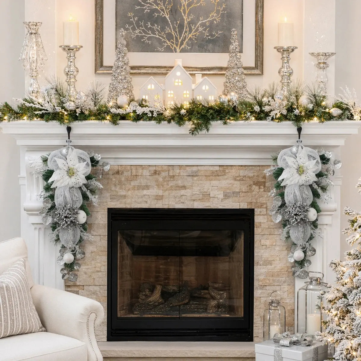 Silver white Christmas teardrop swags flanking a stone fireplace mantel, styled with frosted pine garland, white poinsettia blooms and silver ball ornaments
