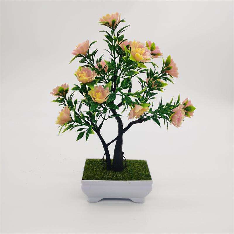 Artificial pine bonsai in decorative pot on office desk – faux welcoming pine plant