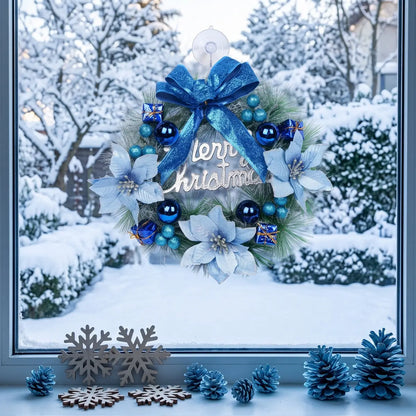 Artificial pine Christmas wreath with blue glitter bow, white poinsettias, blue ball ornaments and Merry Christmas sign, displayed on a snowy window