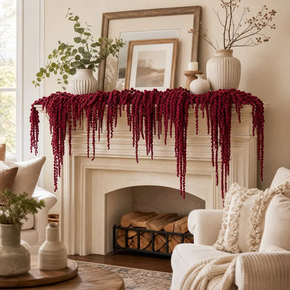 Burgundy artificial amaranthus stems draped over fireplace mantel for holiday decor