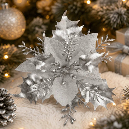 Silver poinsettia pick arranged on snowy evergreen branches