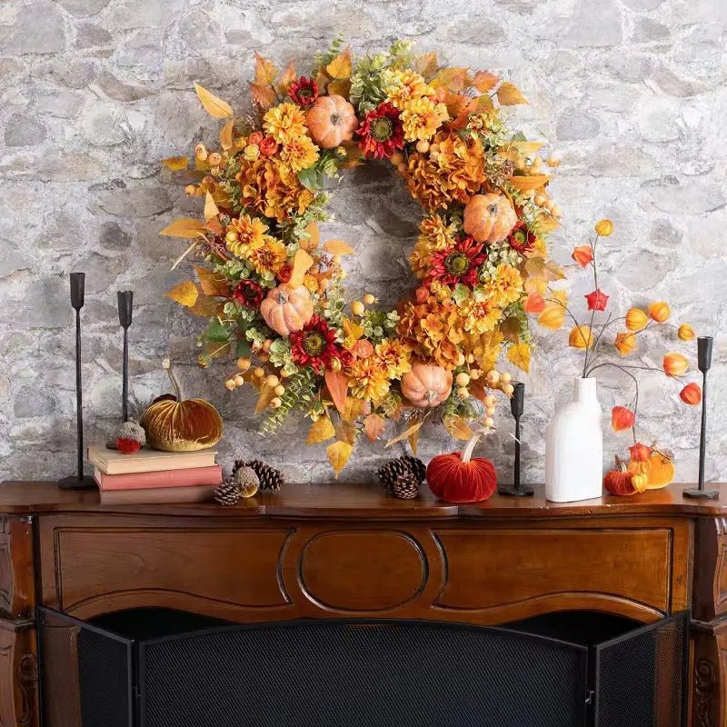 Autumn front door wreath with maple leaves, pumpkin, hydrangea and berry displayed on a wooden console table with candles and fall home decor
