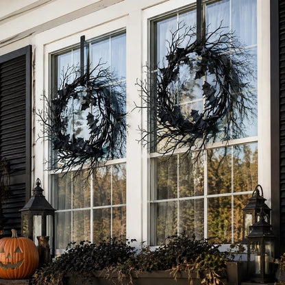 Gothic black bat wreath styled on window frame with Halloween seasonal decor and candles