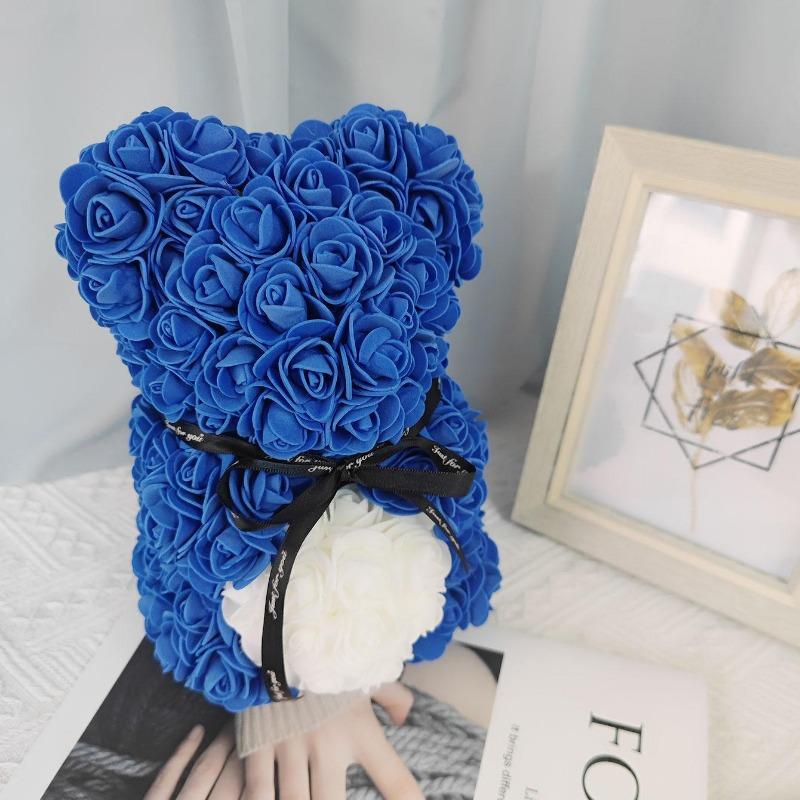 Blue rose teddy bear with black ribbon in colorblock gift box
