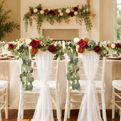 Artificial burgundy orange ivory rose eucalyptus garland on white Chiavari chairs at indoor wedding reception – IPOPU
