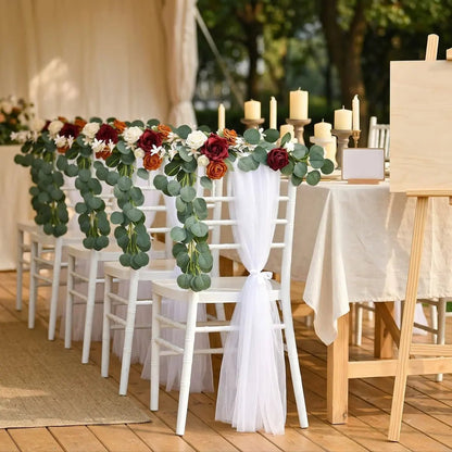 Artificial burgundy rose eucalyptus garland draped over white Chiavari chairs at tent wedding reception with candles – IPOPU

