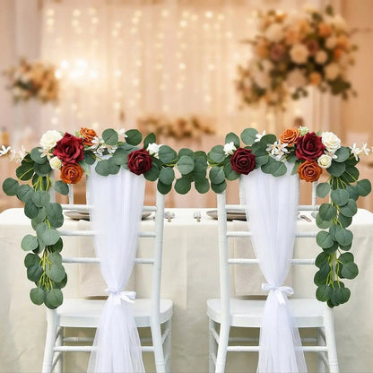 Artificial burgundy orange ivory rose eucalyptus garland on white Chiavari chairs at fairy light ballroom reception – IPOPU
