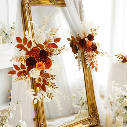 Set of 2 burnt orange artificial flower swags styled on a white wedding arch with boho floral accents
