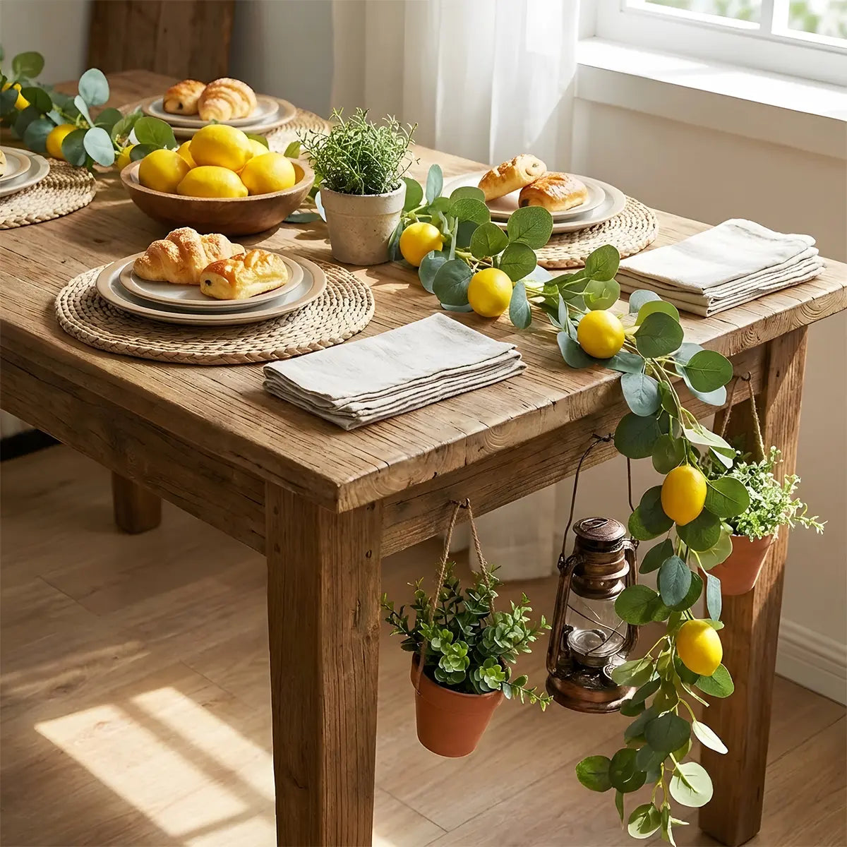 Artificial lemon greenery garland laid along formal dining table centerpiece with white ranunculus flowers and cane table runner, wedding table décor