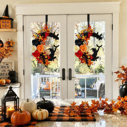 Crescent moon Halloween wreath with black witch and bat silhouettes displayed on double white French doors with pumpkins and lanterns