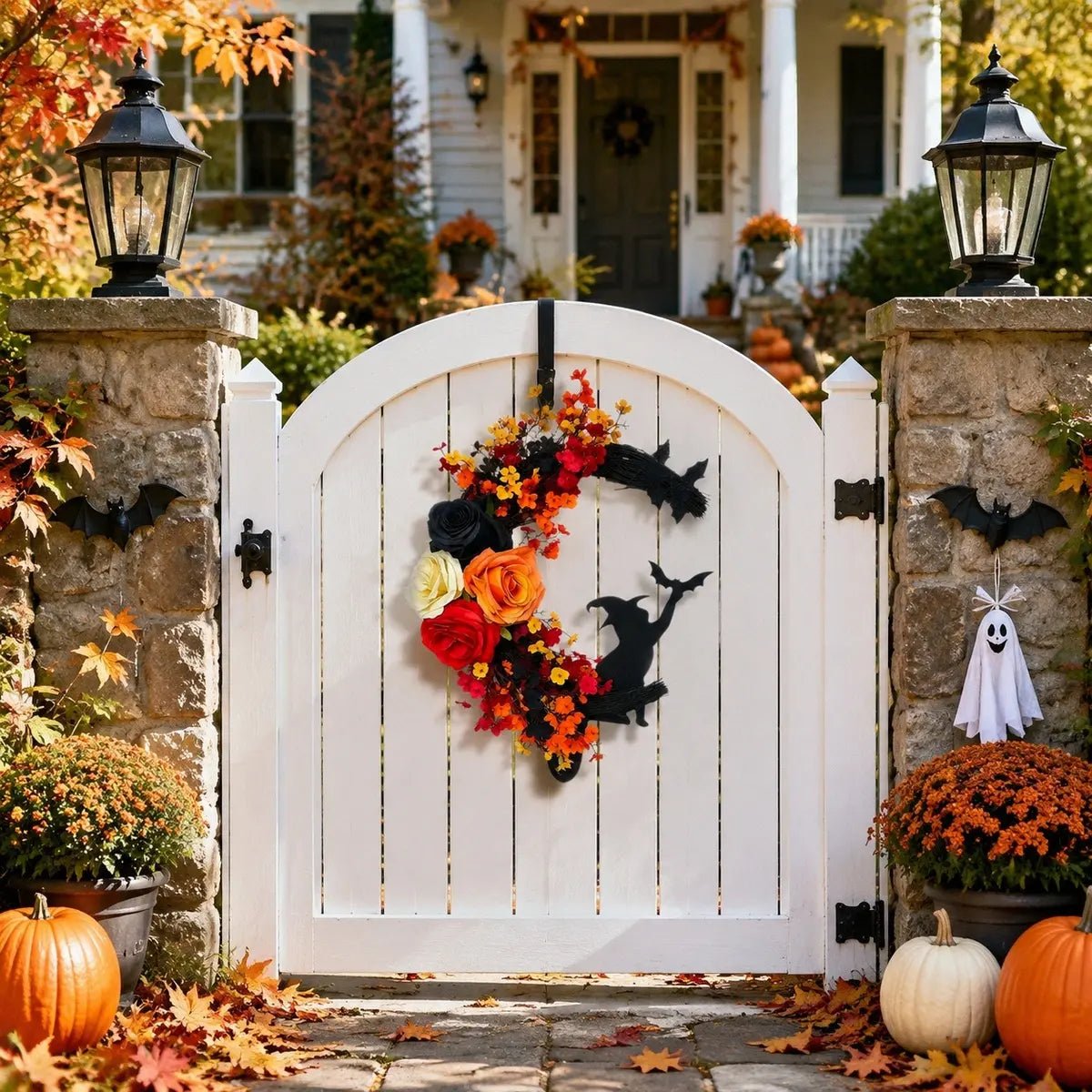 Crescent moon Halloween wreath displayed on a white garden gate with fall foliage and pumpkin decorations