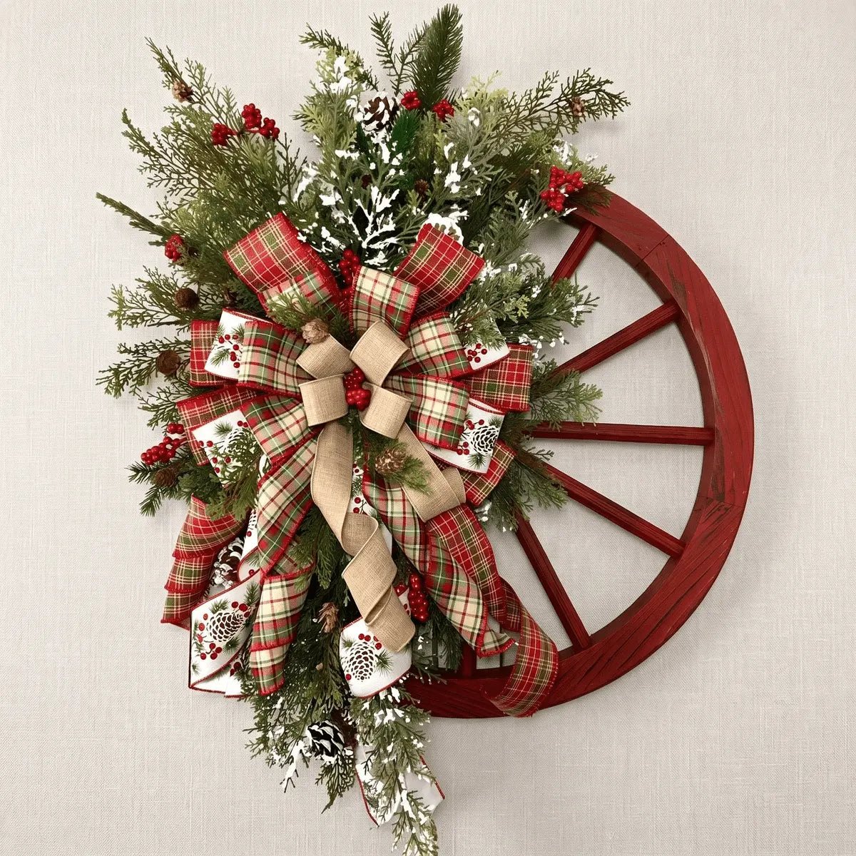 Farmhouse wooden wagon wheel Christmas wreath with snowflake and berries displayed on a neutral wall for indoor home decor