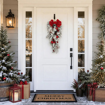 Red bow flocked Christmas teardrop swag displayed on a front door