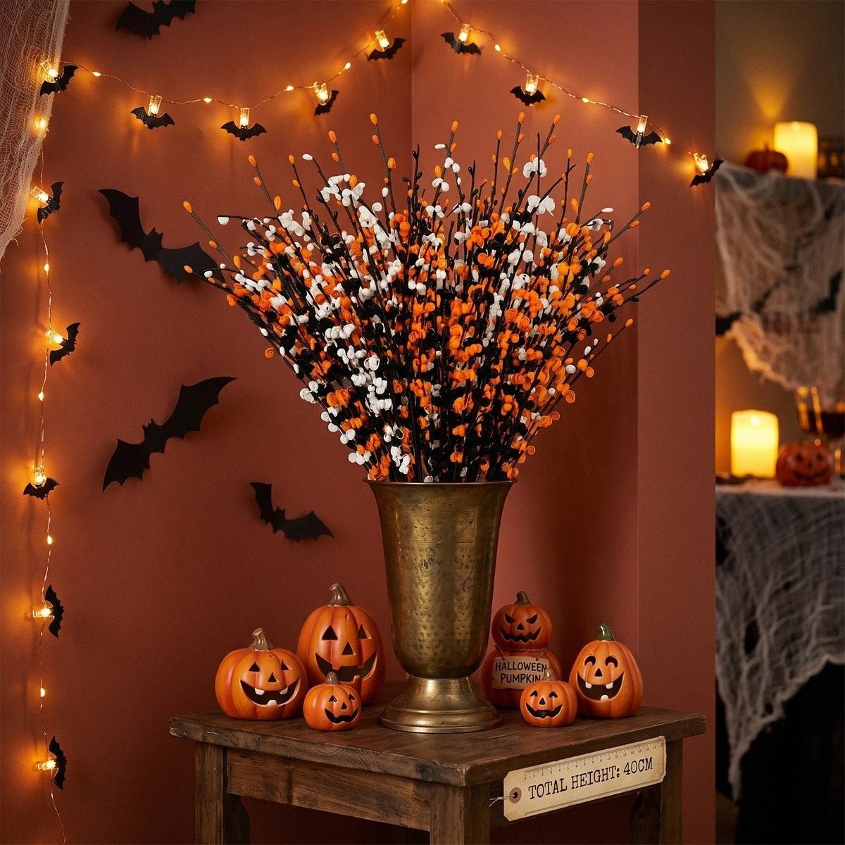Halloween jasmine floral picks in orange, white and black mixed into a gothic DIY wreath arrangement with pumpkins and dark foliage