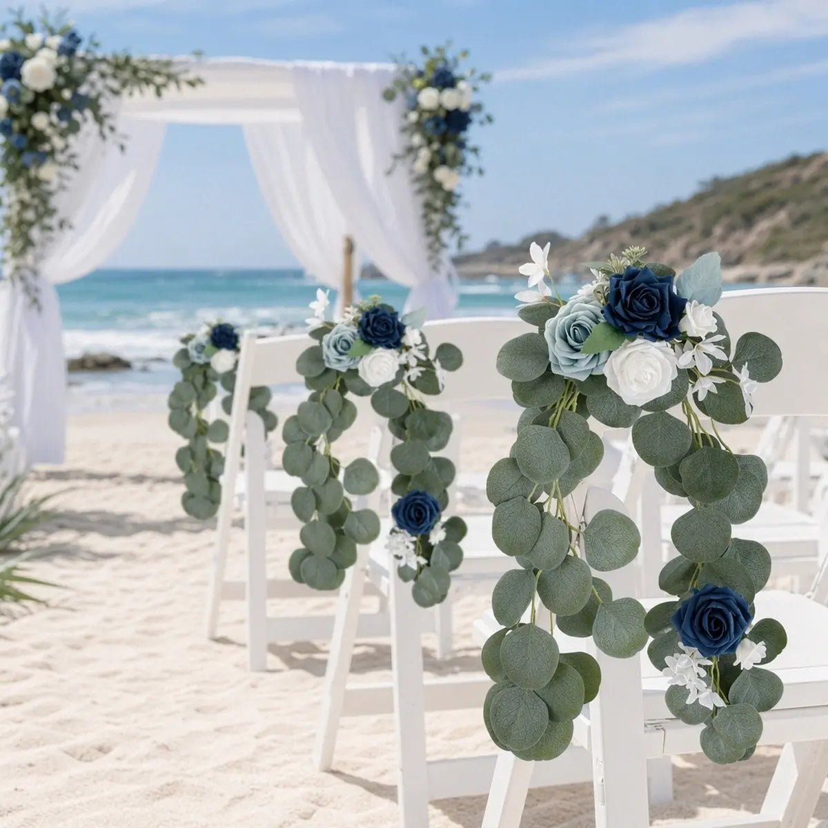 Navy blue dusty blue white rose silver dollar eucalyptus chair swag set of 2 draped on white folding aisle chairs at outdoor beach wedding ceremony with wood arch backdrop – IPOPU