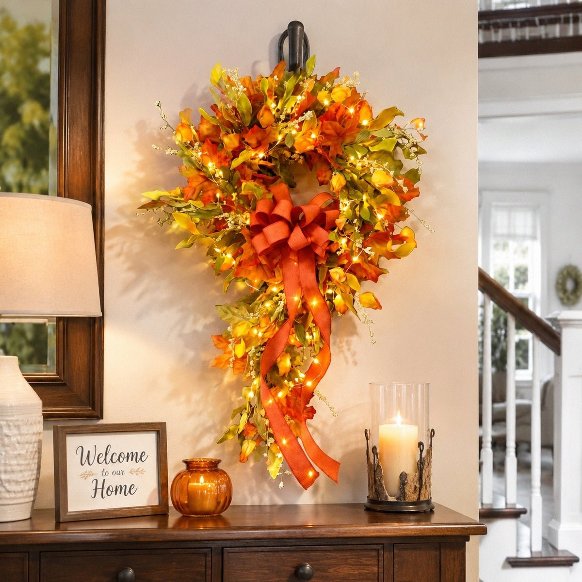 Orange fall teardrop swag wreath with maple leaves and bow hanging on wall – IPOPU

