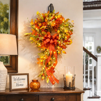 Orange fall teardrop swag wreath with maple leaves and bow hanging on wall – IPOPU
