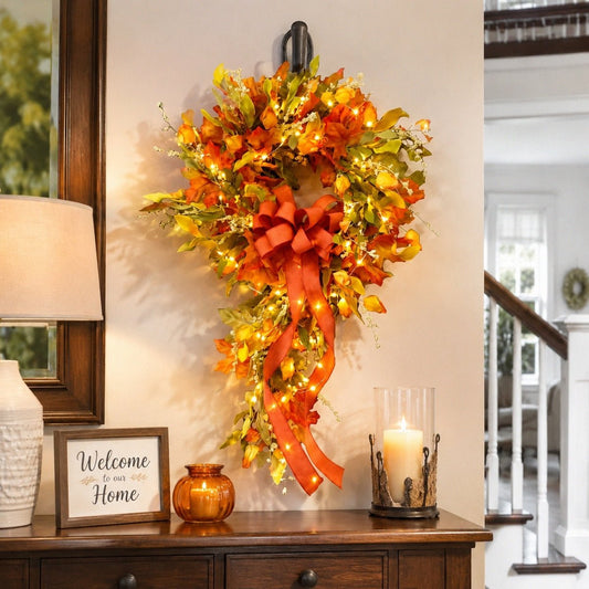 Orange fall teardrop swag wreath with maple leaves and bow hanging on wall – IPOPU
