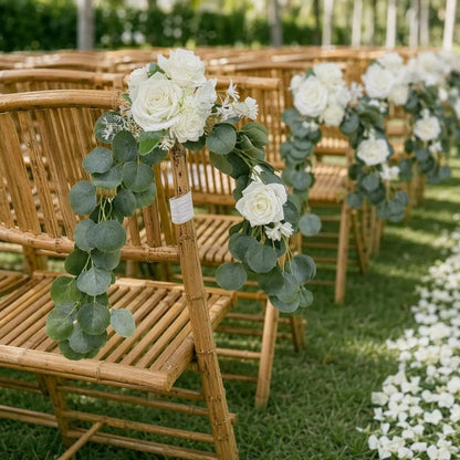 White rose silver dollar eucalyptus chair swags hung on bamboo rattan aisle chairs at outdoor garden wedding ceremony with white rose petals on grass – IPOPU